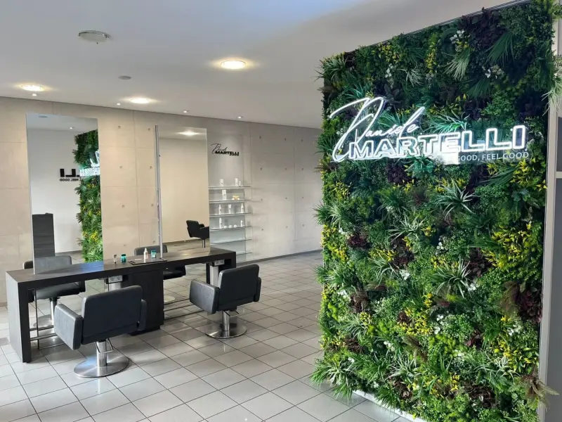 Styling-Plätze mit Pflanzenwand und Neon-Logo