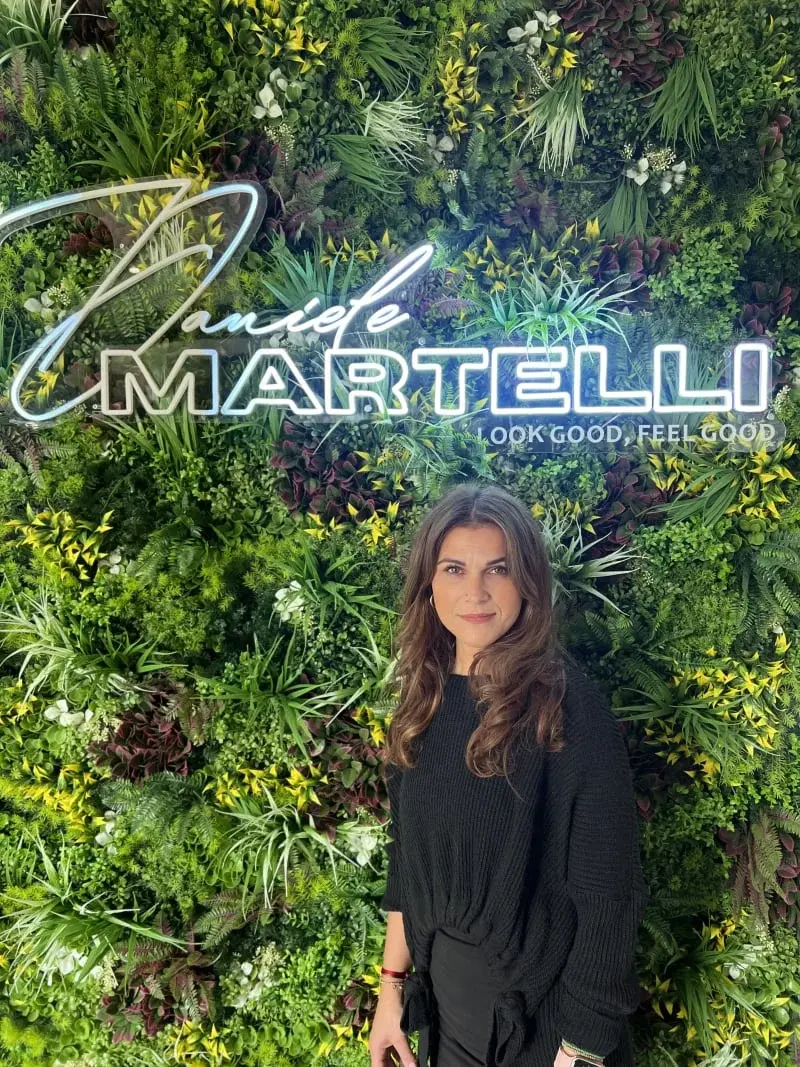 Stylistin Eleni vor der Pflanzenwand