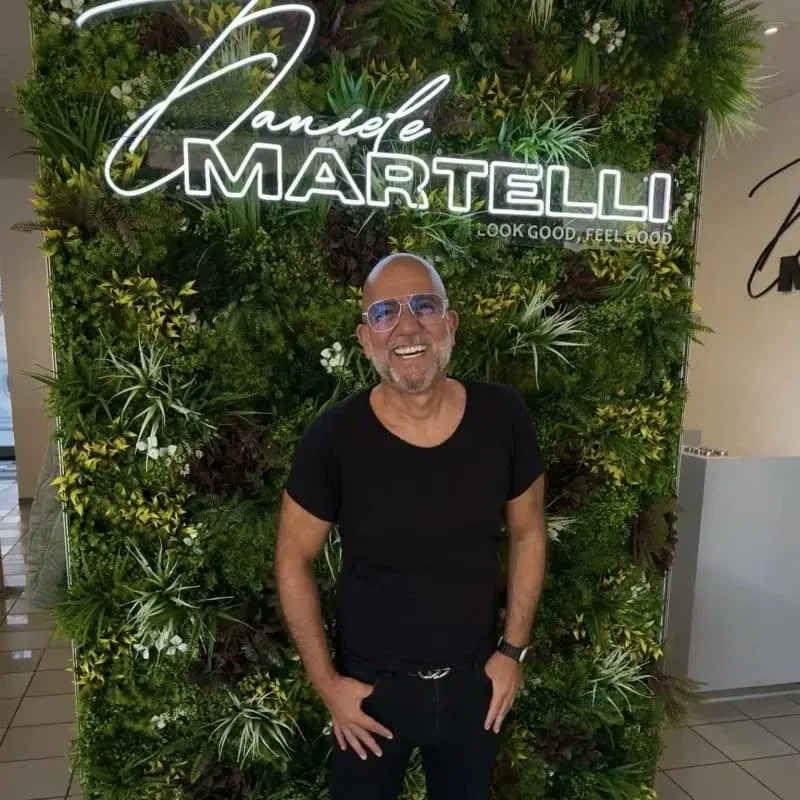 Stylist Frank vor der Pflanzenwand