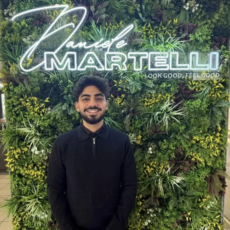 Stylist Moe vor der Pflanzenwand